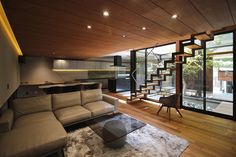 modern living room with stairs leading up to the upper floor and glass doors on both sides