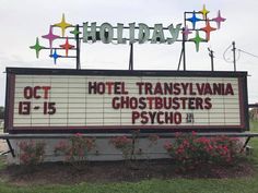 a sign for the hotel transaviana ghostbusters psychcho in front of flowers