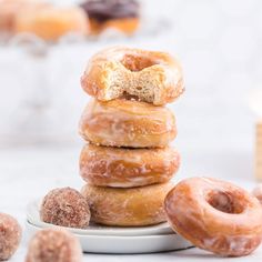 a stack of doughnuts sitting on top of a plate next to other donuts