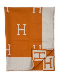 an orange and white blanket with the letter h on it