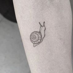 a small snail tattoo on the leg