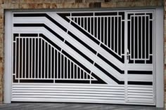 a white and black gate in front of a brick building