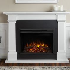 a white fireplace with fire burning in it