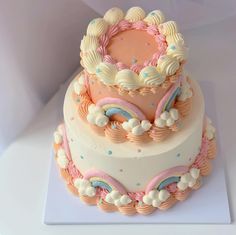 a three tiered cake is decorated with pastel colors