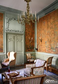 a living room with two chairs and a chandelier