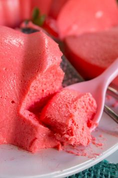 a white plate topped with pink ice cream next to a bowl of watermelon