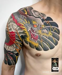 a man with a dragon tattoo on his arm and chest is standing in front of a white wall