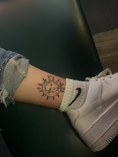 a woman's arm with a small sun tattoo on it