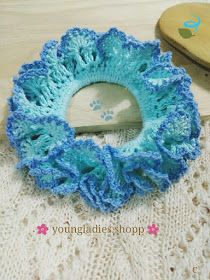 a crocheted blue and white doily with a wooden object in the background