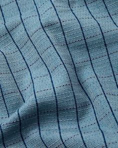 a blue and white striped shirting material that is very close to the camera lens