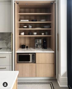 a kitchen with wooden cabinets and white counter tops, along with a microwave on the wall