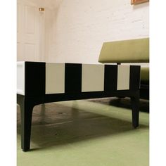 a black and white coffee table sitting on top of a green floor next to a brick wall