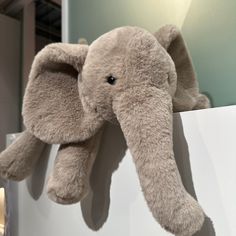 an elephant stuffed animal sitting on top of a white box