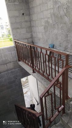 an empty stairway in the middle of a building with concrete walls and metal railings