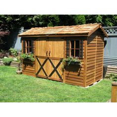 a wooden shed with windows and flowers in it