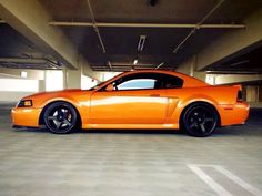 an orange sports car parked in a parking garage