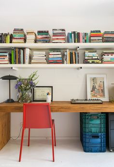 a desk with some books on top of it and a chair in front of it