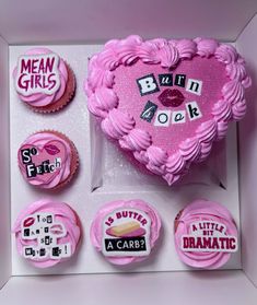 a pink heart shaped cake surrounded by cupcakes and magnets with words written on them