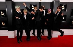 group of boys in tuxedos posing on red carpet