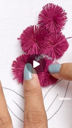 someone is doing something with yarn on their nails and using it to decorate the flowers