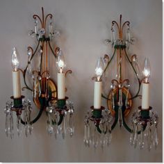 two wall sconces with candles on them