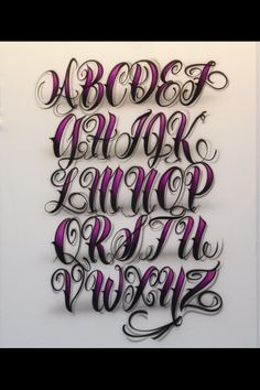 some type of calligraphy that is on display in a room with white walls and purple lettering