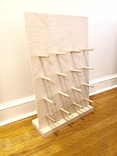 a wooden wine rack sitting on top of a hard wood floor next to a white wall