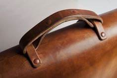 a brown leather case with a handle on it