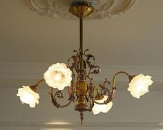 a chandelier hanging from the ceiling in a room with white flowers on it