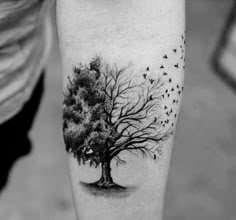 a black and white tree with birds flying around it's branches on the leg