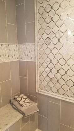 a bathroom with gray and white tile on the walls