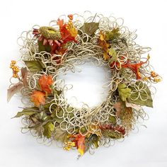 a wreath made out of wire with leaves and flowers on it's front end