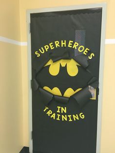 a door decorated to look like a bat with the words superheros in training written on it