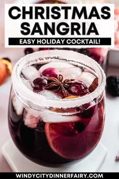 a christmas sangria is served in a glass with ice and garnishes