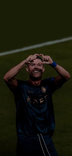 a man standing on top of a soccer field holding his hands up to his head