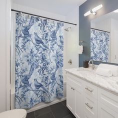 a blue and white shower curtain in a bathroom next to a sink with a toilet