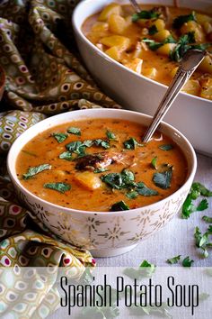 two bowls of spanish potato soup on a table