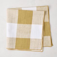 two yellow and white checkered napkins sitting on top of each other