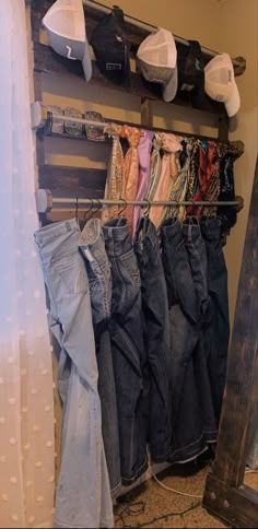 several pairs of jeans are hanging on a rack