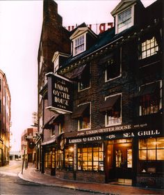 an old fashion store on the corner of a street in front of tall brick buildings