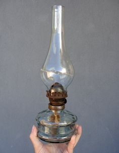 a person holding an old fashioned oil lamp