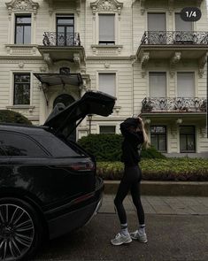 a woman standing next to a car with her trunk open