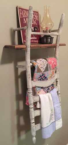 an old wooden ladder with towels hanging on it's side and some books in the background