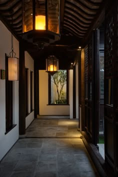 an empty hallway with lanterns hanging from the ceiling