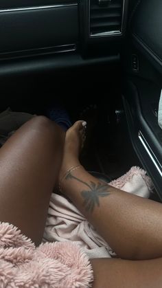 a woman laying in the back seat of a car with her feet up on a towel