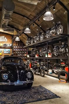 an old car is parked in a garage with many motorcycles on the walls and shelves