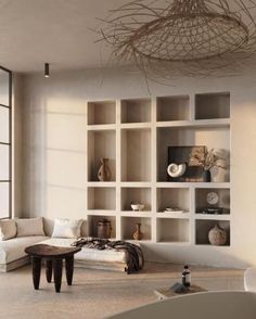 a living room filled with white furniture and lots of shelves on the wall next to a large window