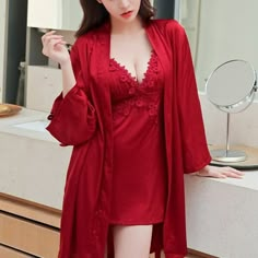 the woman is wearing a red robe and posing in front of a mirror with her hands on her hips