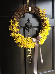 a wreath with yellow flowers hanging on the front door to give it a special touch