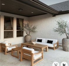 an outdoor living area with furniture and potted plants